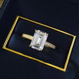 Emerald cut high carbon diamond ring in gold plating with pavé set side stones in a box