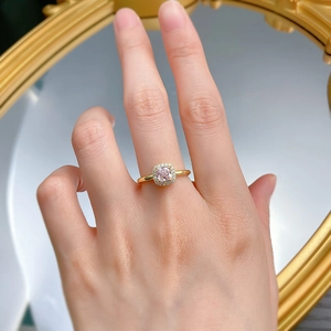 Gros plan d'une bague élégante avec pierre rose taille coussin et halo de diamants