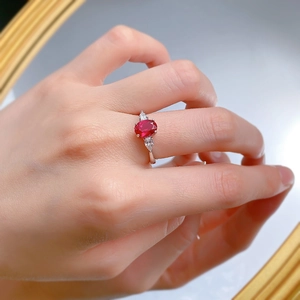 Close-up of S925 silver ring featuring an oval red ruby and teardrop side stones