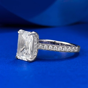 Macro side view of emerald cut gemstone ring with pave diamonds on silver band