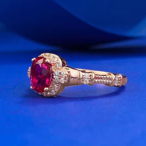Macro side view of a vintage oval red ruby ring with rose gold band and pavé diamonds