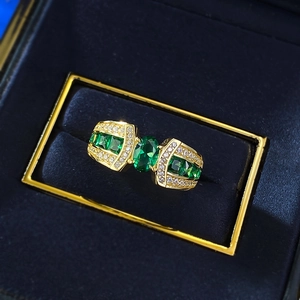 Close-up of a luxury gold-plated silver ring with oval emerald and side diamonds