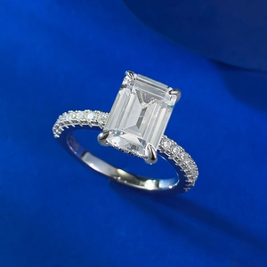 Detail of emerald-cut gemstone ring with pave setting on high-quality silver metal band