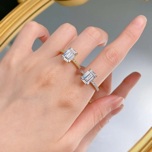 Detail of emerald cut rectangle stone rings in gold and silver plating on hand
