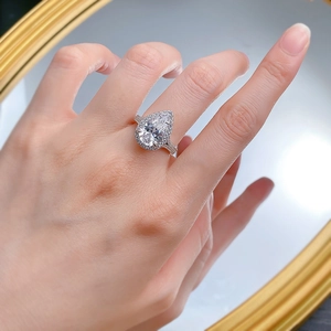Detailed view of S925 silver pear-shaped halo ring with side accent diamonds on finger