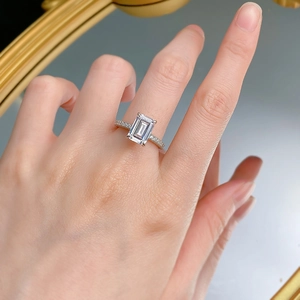 Classic emerald cut s925 silver ring with radiant pave set diamonds worn on a finger