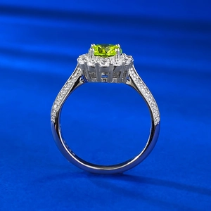 Gros plan d'une bague avec pierre précieuse vert pomme et pavage de diamants halo