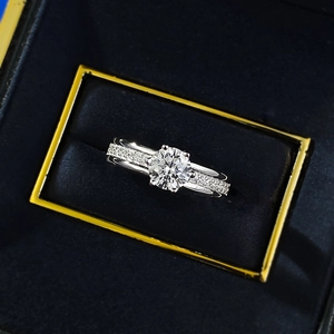 Macro view of 6.0mm round cut ring with pavé side stones in a velvet jewelry box