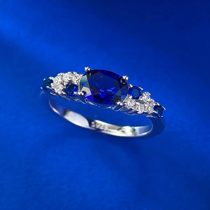 Close-up of S925 sterling silver ring featuring a large oval blue gemstone and side diamonds