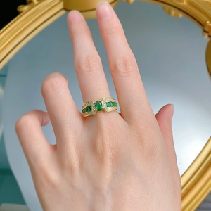 Close-up of gold-plated S925 silver ring featuring an oval green emerald and side stones