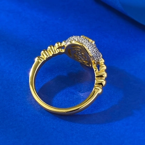 Macro detail of gold-plated ring with pavé-set crystals and textured wavy band