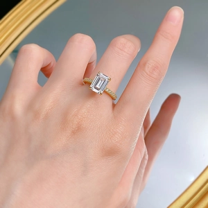 Macro view of emerald-cut carbon diamond ring with pavé side stones on gold band