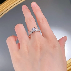 Macro detail of a classic six-prong silver ring featuring a 6mm round moissanite stone