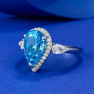 Elegant pear-cut sky blue gemstone ring with a diamond halo and polished silver band