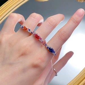 Three elegant S925 silver rings with oval red, orange and blue stones on hands