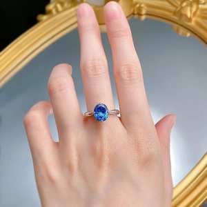 Macro detail of oval royal blue sapphire ring with elegant four-prong silver setting