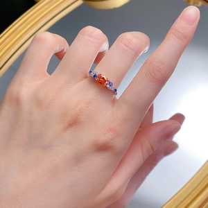 Close-up of S925 silver ring featuring an oval orange stone and blue accents