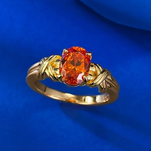 Close-up of S925 sterling silver ring featuring an oval orange stone and braided band
