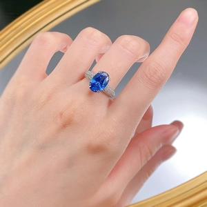 Gros plan d'une bague en argent S925 avec une pierre bleue ovale portée à la main