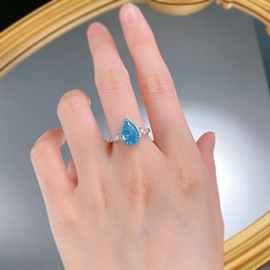 Pear-cut aquamarine high carbon diamond halo ring in S925 sterling silver on finger