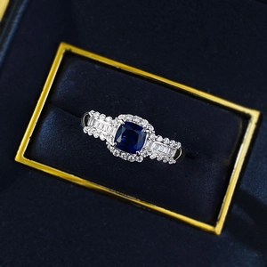 Makroaufnahme eines saphirblauen Rings mit Diamanthalo in einer luxuriösen Box