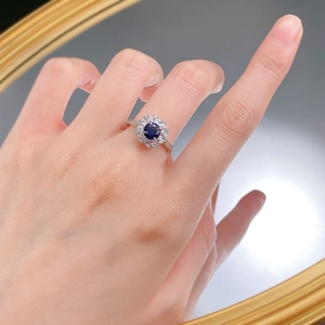 Detail of S925 silver ring with 6mm blue corundum and floral halo diamond accents