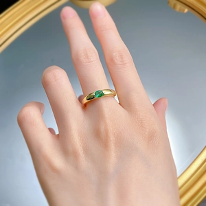 Close-up of a 925 silver gold-plated ring featuring a green oval emerald gemstone
