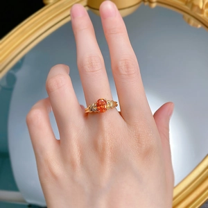Macro view of S925 silver ring with oval orange gemstone and woven band details