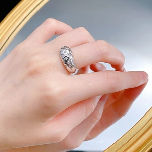 Macro shot of wide silver ring with mixed-cut cubic zirconia and refined craftsmanship