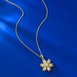 Gold-plated daisy pendant necklace with white crystals on a luxury blue background