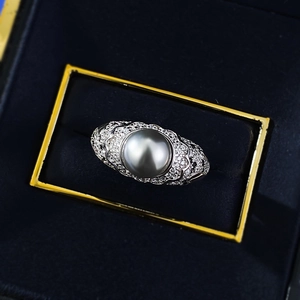 Macro shot of 8mm gray pearl ring with sparkling diamond pavé and vintage wavy silver band