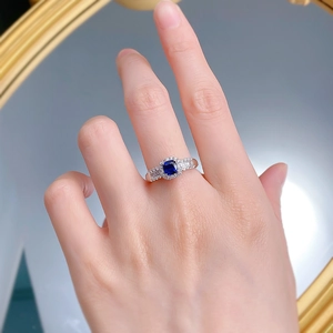 Nahaufnahme von Damenring mit königsblauem Saphir und Silberband am Finger