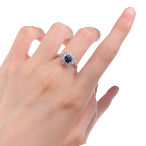 Elegant S925 silver ring with 6mm blue sapphire and halo diamond setting on finger