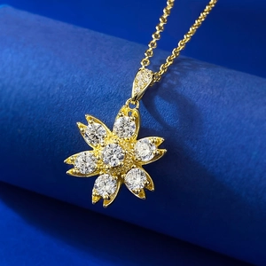 Macro detail of gold S925 silver daisy pendant with sparkling white cubic zirconia stones
