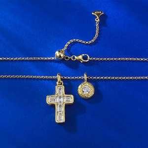 Macro detail of gold S925 silver cross pendant with zircon stones on dark blue surface