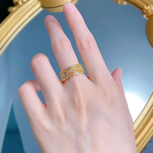 Macro detail of a gold-plated lattice lace ring with sparkling crystals on a model's hand