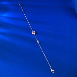 Detail of S925 silver bracelet featuring a pigeon blood red gemstone with floral halo