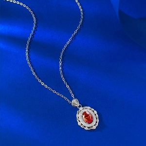 Détail macro du pendentif ovale serti de pierre orange et diamants sur chaîne argent