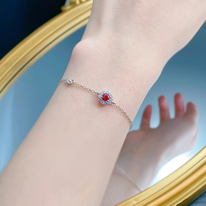 Macro view of S925 silver bracelet featuring a pigeon blood red gemstone floral charm