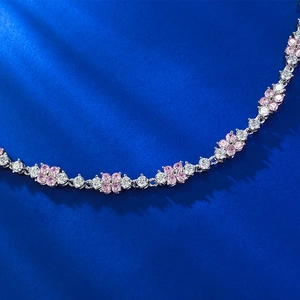 Dettaglio del bracciale a fiori in argento 925 con gemme rosa su sfondo di seta blu scuro