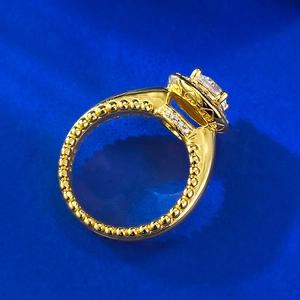 Vue détaillée d'une bague halo en argent S925 plaqué or avec des bords milgrain fins