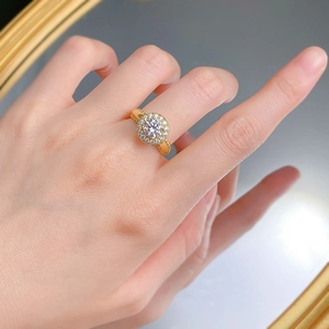 Détail d'une bague Halo avec pierre ronde et accents pavés portés par un mannequin
