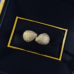 Vista macro di orecchini a goccia con pavé in un lussuoso portagioie blu navy e oro