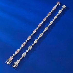 Dettaglio di bracciali in argento 925 con fiori di zircone rosa e bianchi su fondo blu