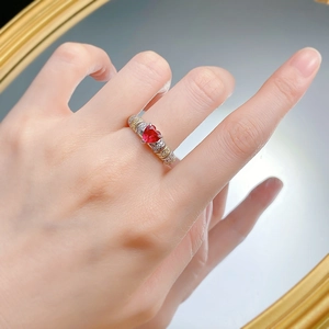 Détail d'une bague rubis en cœur avec anneau bicolore argent et or sur un miroir