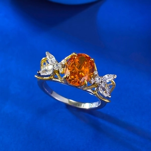 Macro detail of oval orange gemstone ring with silver and gold two-tone setting