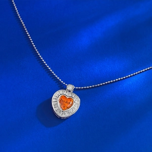 Macro detail of S925 silver heart necklace with orange zircon and baguette-cut frame