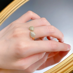 Dettaglio di anello bohémien dorato con cristalli a goccia e riflesso nello specchio