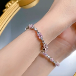 Dettaglio di un bracciale in argento 925 con gemme a forma di fiore rosa e bianche