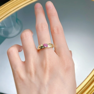 Detailed close-up of S925 gilded ring featuring a pear-cut pink gem and hammered texture